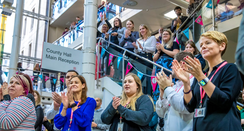 Group of people clapping at the end of a talk in the couty hall main reception